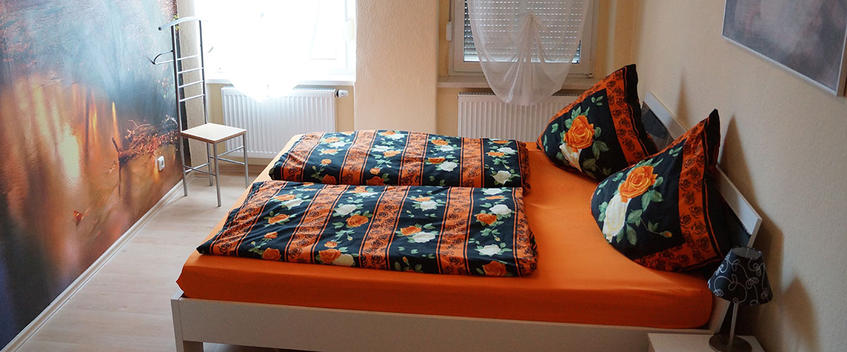 Helles Schlafzimmer der Ferienwohnung mit Doppelbett und Kleiderschrank